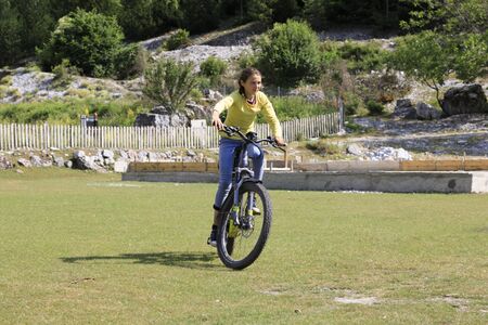 Theth, Albania, July 5 2019: An Albanian girl in Theth is riding an e-bike from a touristのeditorial素材