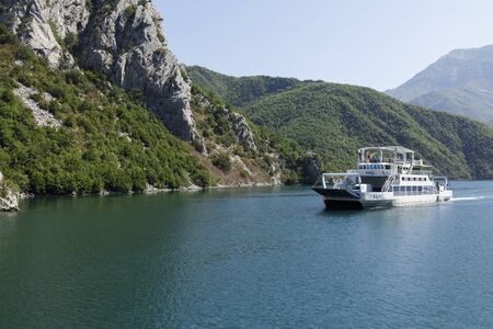 Koman, Albania, July 7 2019: An oncoming ferry at a narrow spot on the Komani Lake in the Dinaric Alps of Albaniaのeditorial素材