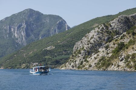 Koman, Albania, July 7 2019: An oncoming tourist boat on the Komani lake in the dinaric alps of Albaniaのeditorial素材
