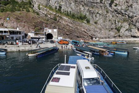 Koman, Albania, July 7 2019: A car and passenger ferry departs in Koman, Komani lake, a 35km long reservoir in the dinaric alpsのeditorial素材