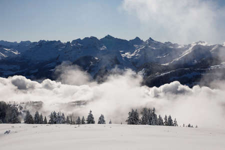 Winter landscape with fog towards Ibergeregg and Moutathal in central Switzerlandの写真素材