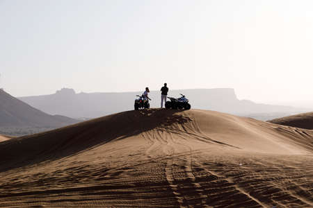 Riyadh, Saudi Arabia, February 15 2020: Two young Saudis take a break with their quads on the top of...