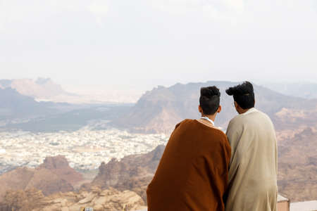 Al Ula, Saudi Arabia, February 19 2020: Two Saudi Arabian youths look from a viewpoint in the...