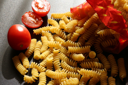 Italian pasta, still life on black background with tomatoesの写真素材