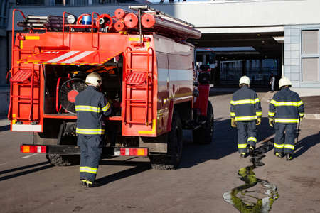 Three firefighters extinguish a fire in an apartment house