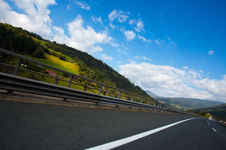 Road, green meadows, blue sky photo for youの写真素材