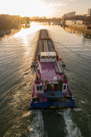 Quays of the Seine. View of the freight of a barge sailing along the Seine and The Defense district at sunset from Clichy Bridgeの写真素材