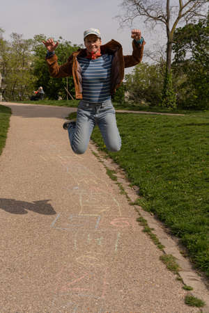 Park of the Buttes Chaumont. Close up shot of a woman playing hopscotchの写真素材