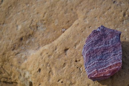 A purple rock on a brown rock. Found in Petra, Jordan.の写真素材