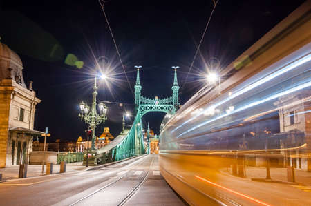 Night view of tram on Liberty Bridge or Freedom Bridge with lens flares in Budapest, Hungary.の写真素材