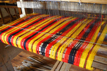 An old loom with colourful wool ready for weaving