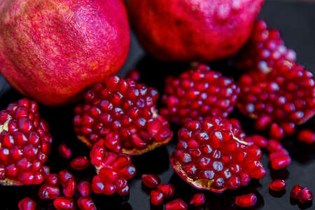 Some ripe juicy red pomegranate fruit on the plate. (Punica granatum)の写真素材