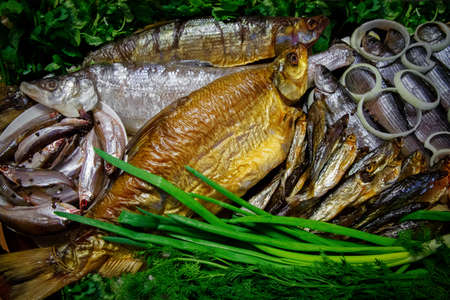 Smoked and salted river fish in the range served with vegetables and herbs. The view from the top.の写真素材