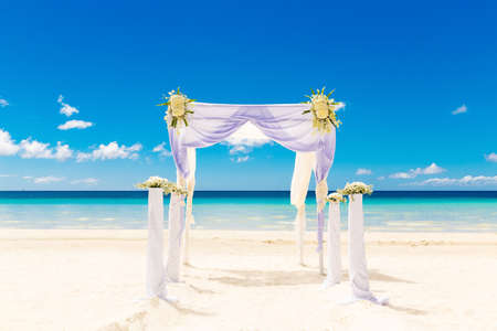 Wedding on the beach. Wedding arch decorated with flowers on tropical sand beach.の写真素材