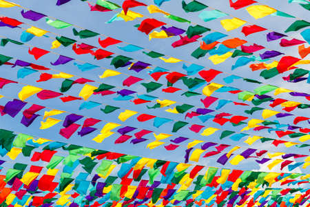 Multicolored ribbons against the blue sky. Festive decoration of the city streets for the spring...