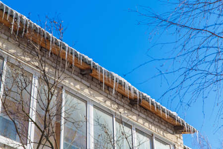 Icicles hanging from the roof. Winter in town.
