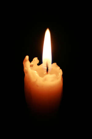 The burning melted off candle on a dark background.の写真素材