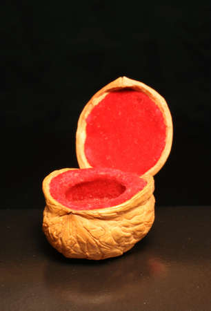 Casket for jewelry from a walnut on a dark background. Manual work. With an open cover.