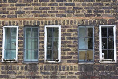 Several small vintage windows in a brick antique wall. Street photo.の写真素材