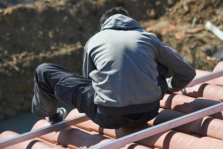 Workers installing solar panels on residential house roofの写真素材