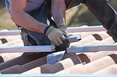 Workers installing solar panels on residential house roofの写真素材