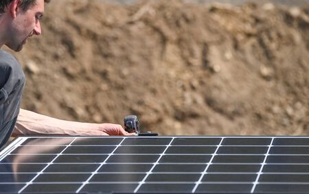 Workers installing solar panels on residential house roof
