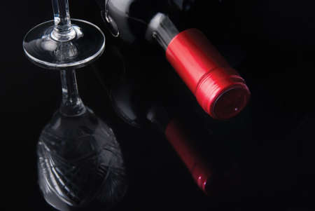bottle of wine and a glass of red label on a black mirrored backgroundの写真素材