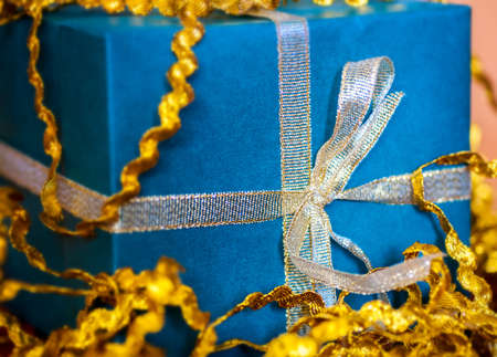 Photo of a gift box with a blue and gold out of focusの写真素材