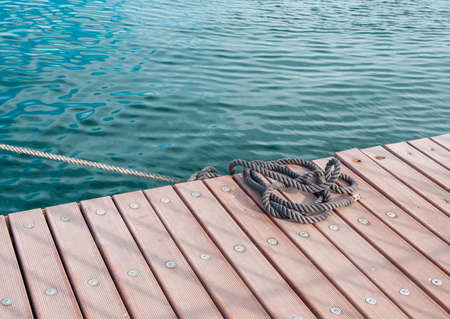 Coiled marine rope on wooden pierの写真素材