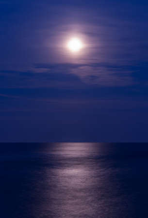 Full moon over the sea, vertical shotの写真素材