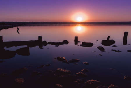 Colorful bright orange red summer sunset over lakeの写真素材