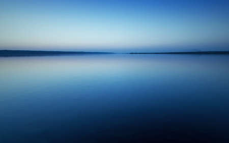 Colorful bright blue summer sunset over lakeの写真素材