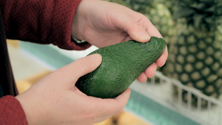 Women hands choose avocado in store. Close up shot of handsの写真素材