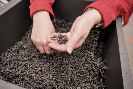 Woman in a building materials store buys screws self tapping. Hands close up shot. Concept of women...