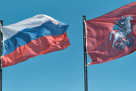 Flag of Russian Federation and flag of Capital of Russia - Moscow with image of George Victorious fluttering in the wind.の写真素材