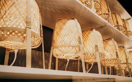 There are many wicker wooden lamps on the store shelf. Concept of interior design and decoration