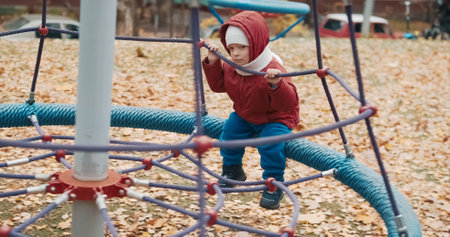 Small, cute child rides on a swing in the yard on a walk. The carousel rolls the baby. Lifestyle and active recreationの写真素材