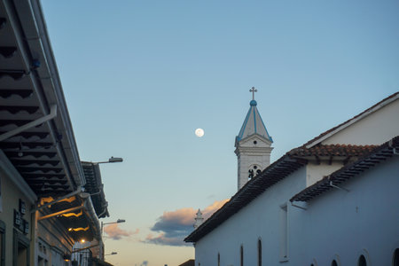 The moon rises over the city Cuencaの写真素材