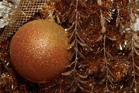 a golden ornament on golden christmas treeの写真素材