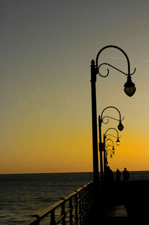 People watch the sunset at the pierの写真素材