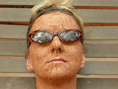 Woman wears her sunglasses while getting a mud facialの写真素材