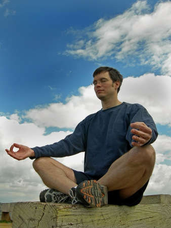 Man meditates outside on a benchの写真素材