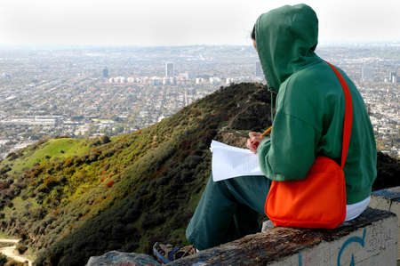 Woman working & taking notes outside.の写真素材