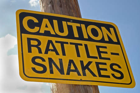 "Caution Rattle-Snake" sign hanging on postの写真素材