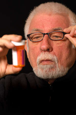 Older man tries to read pill bottleの写真素材