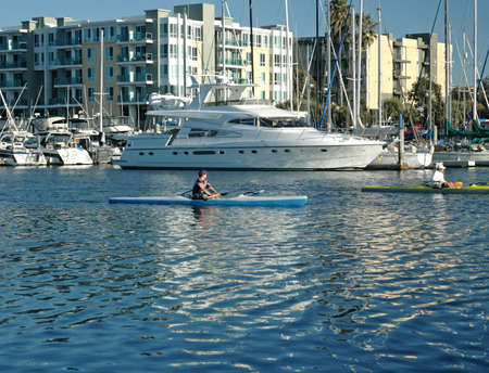 Kayaker rows past a large yacht