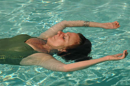 Woman floats in pool on her long awaited vacation