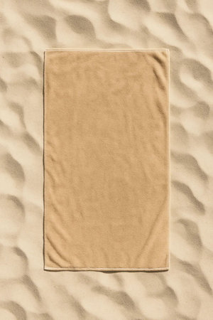 Beach towel on sand background. Top view. Copy space.の素材