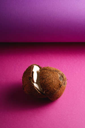 Coconut fruits on purple violet folded paper background, abstract food tropical concept, angle view copy spaceの写真素材