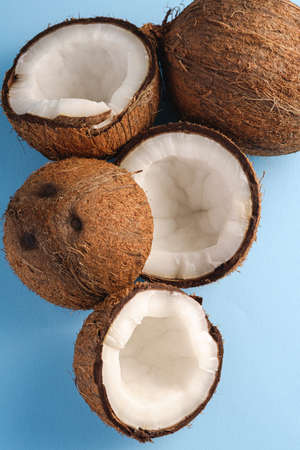 Coconut fruits on blue vibrant plain background, abstract food tropical concept, top view macroの写真素材